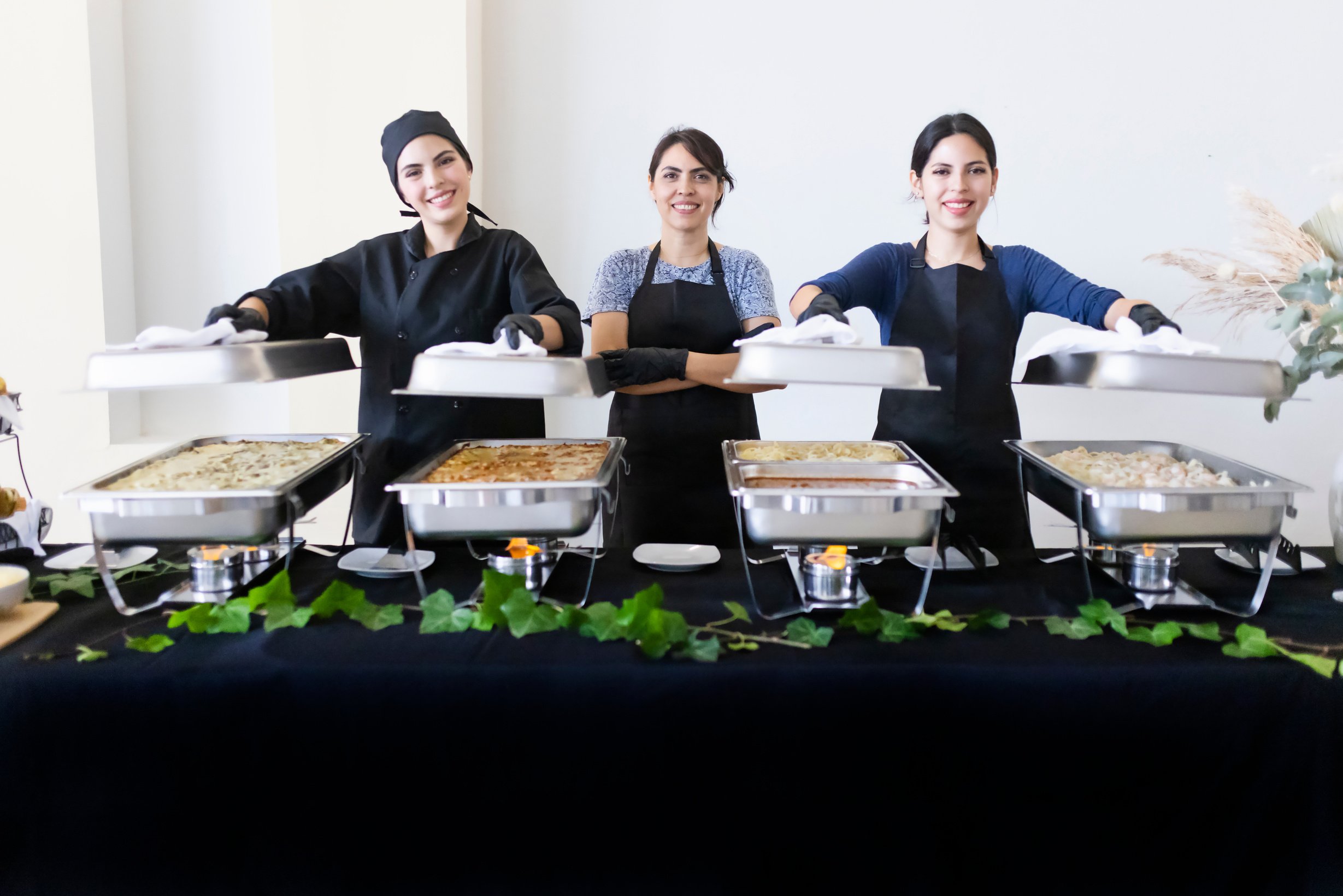 Entrepreneurial mother and daughters of the event caterer happy and ready to serve you.